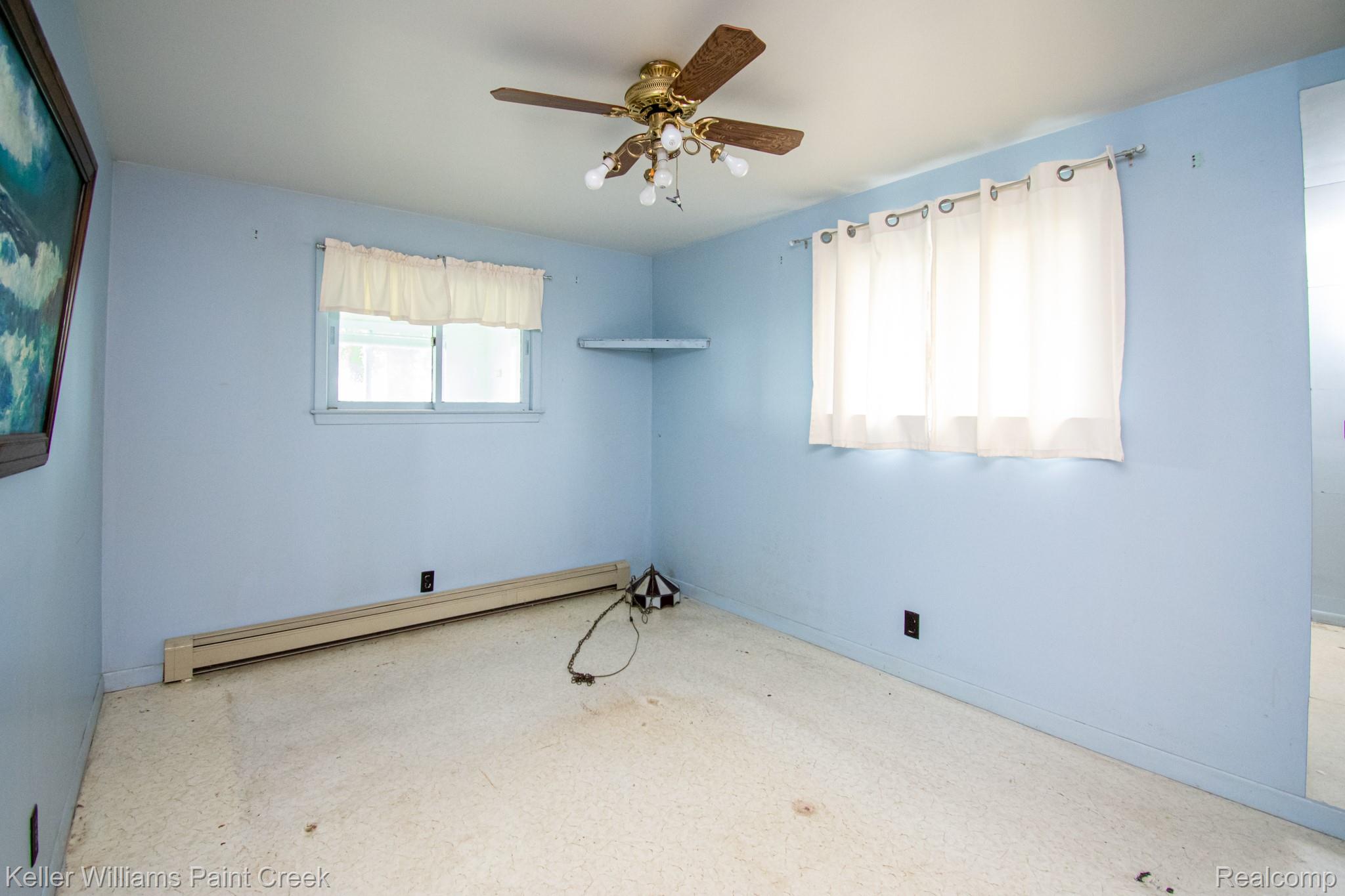 6533 River Road Marine City, MI 48039 - Photo 10 of 17 Spare room featuring baseboard heating and a ceiling fan
