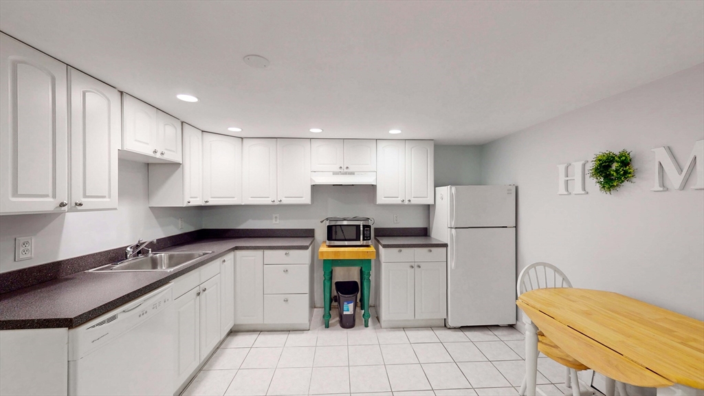 13 West Street Woburn, MA 01801 - Photo 20 of 30 a kitchen with a white refrigerator freezer a stove and a sink
