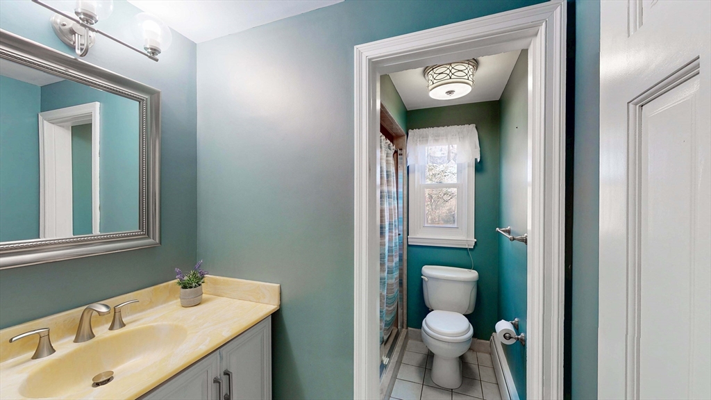 13 West Street Woburn, MA 01801 - Photo 9 of 30 a bathroom with a toilet sink and mirror