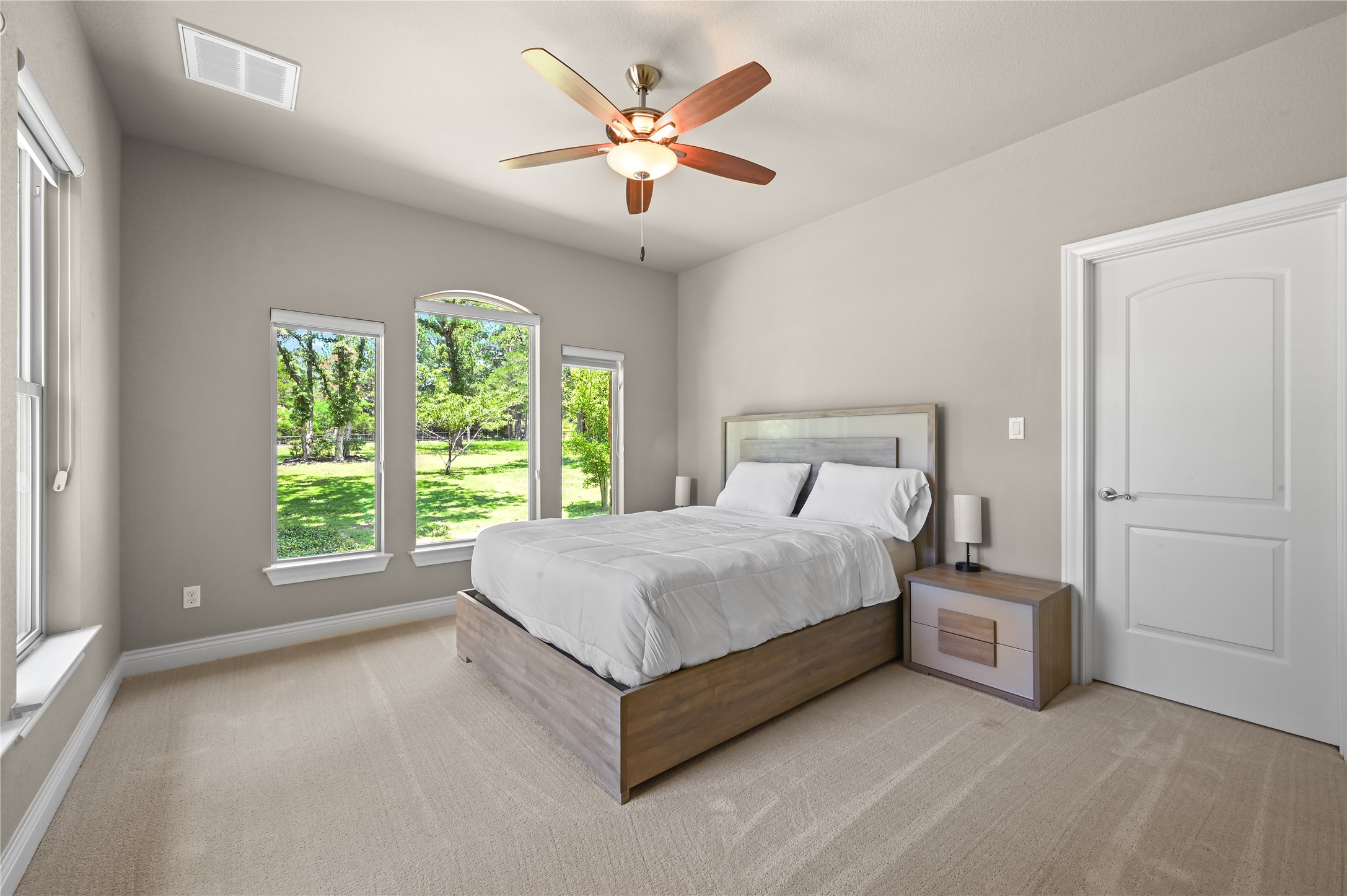 387 Corral Road Smithville, TX 78957 - Photo 25 of 40 Bedroom featuring multiple windows, a vaulted ceiling, ceiling fan with light fixture, and neutral carpeting