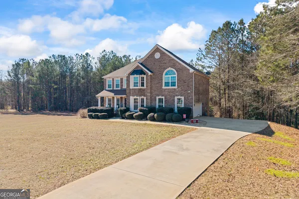 a front view of a house with a yard covered with snow
