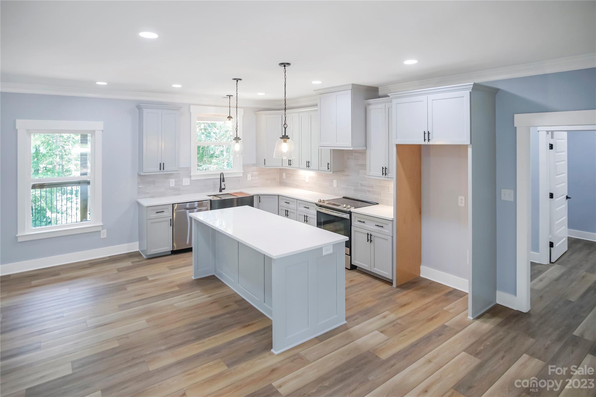 7550 Webbs Road Denver, NC 28037 - Photo 14 of 46 a large kitchen with stainless steel appliances granite countertop a stove a sink dishwasher a refrigerator and white cabinets with wooden floor