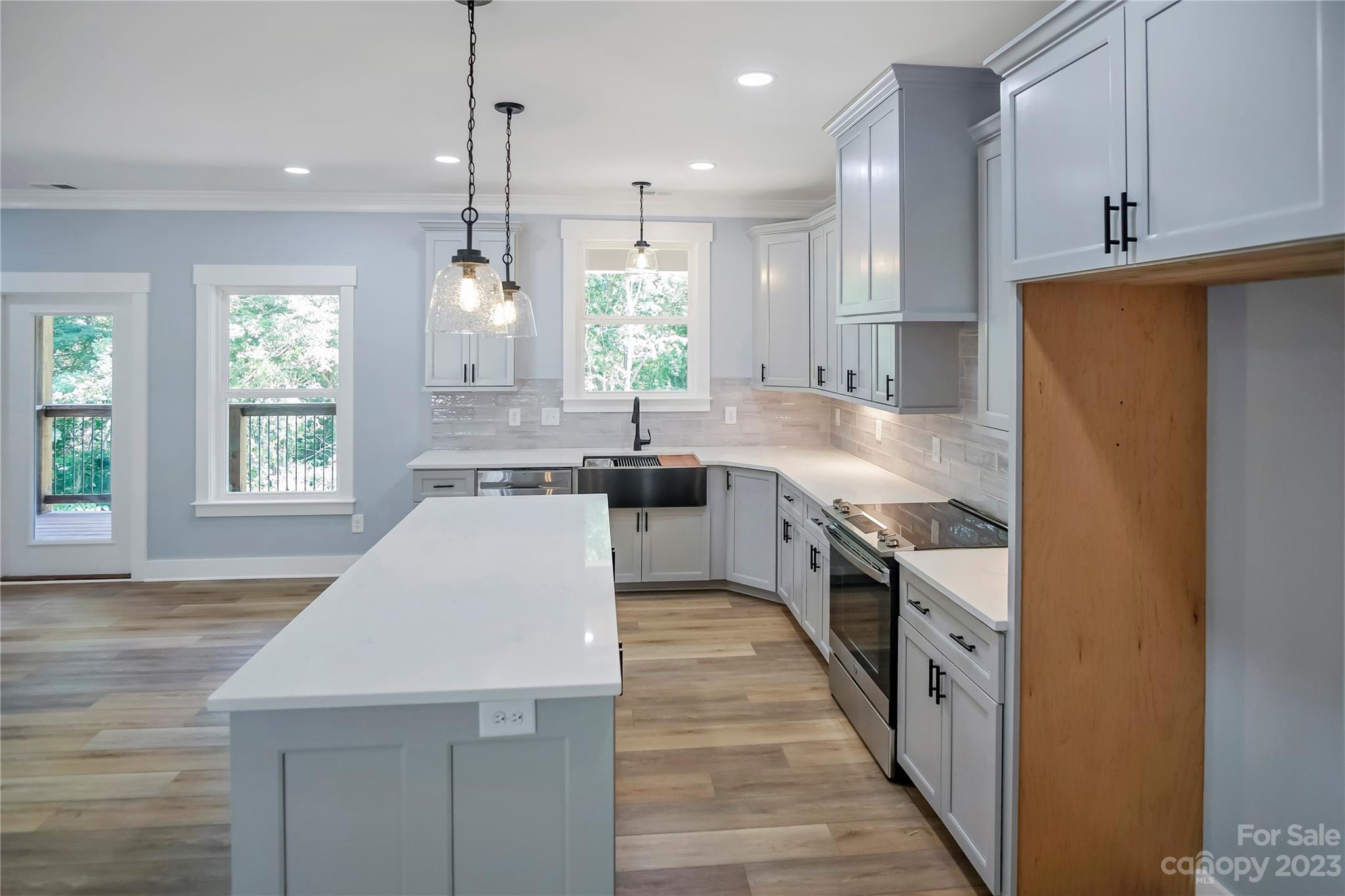 7550 Webbs Road Denver, NC 28037 - Photo 17 of 46 a large kitchen with granite countertop a sink a counter space appliances and windows