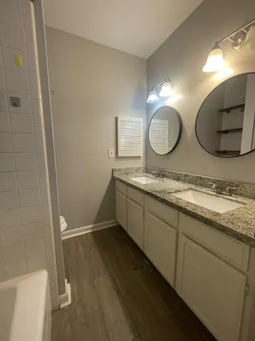 a bathroom with a double vanity sink and a mirror