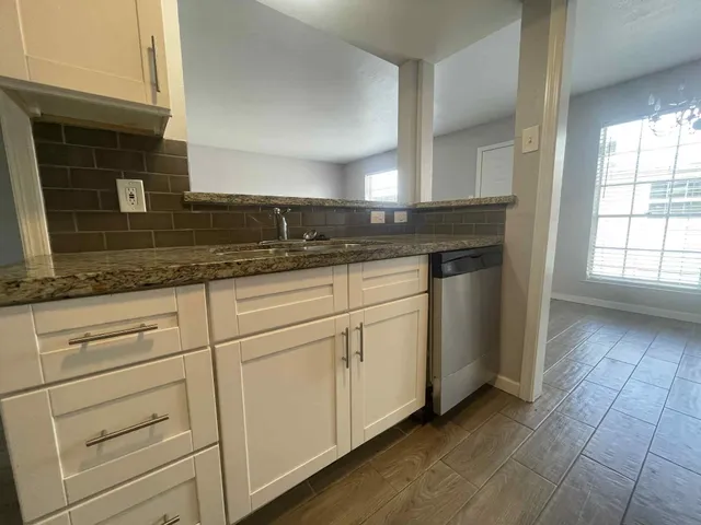 a kitchen with granite countertop white cabinets and white appliances