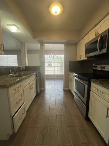 a kitchen with stainless steel appliances granite countertop a stove a sink and a microwave