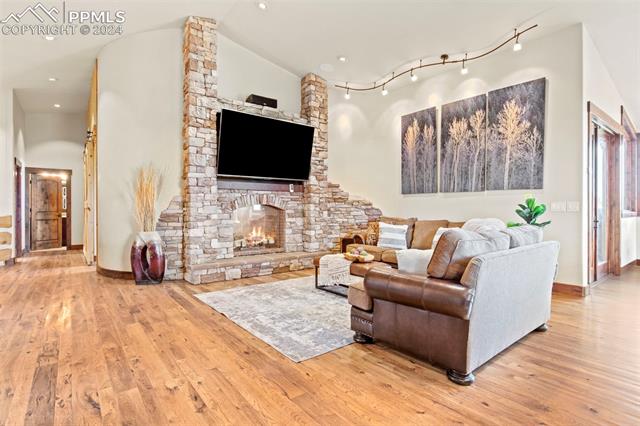 7115 Wildridge Road Colorado Springs, CO 80908 - Photo 18 of 49 Living room with large stone double-sided fireplace fireplace