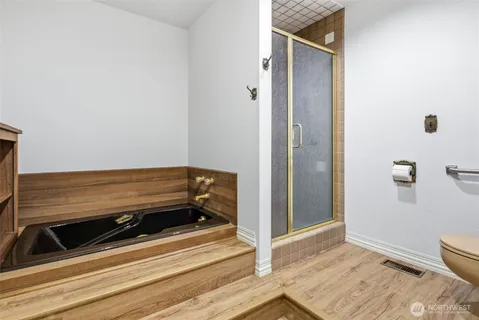a view of a livingroom with wooden floor and bathroom