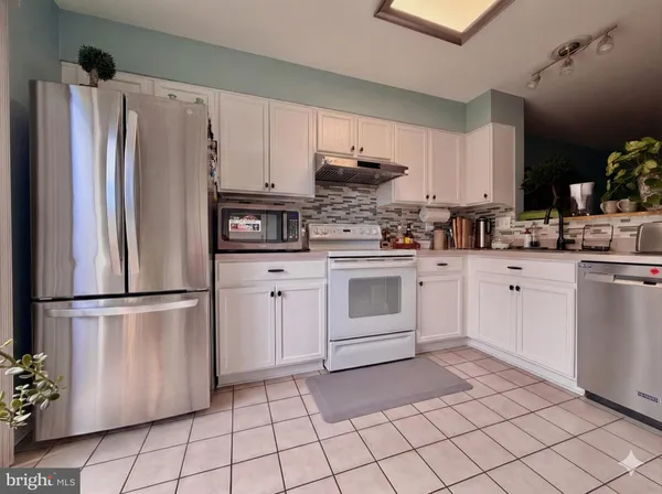 a kitchen with stainless steel appliances a refrigerator sink and cabinets