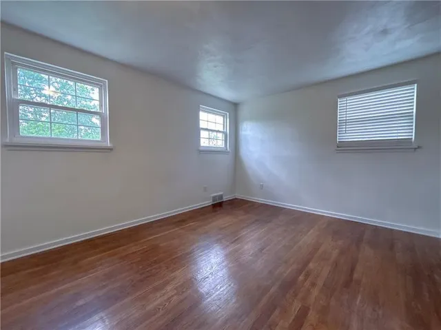 a view of an empty room with wooden floor