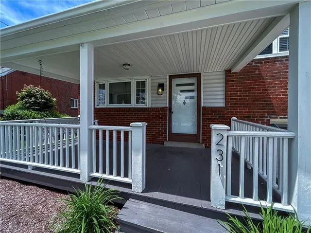 a view of a house with a small yard and wooden floor and fence