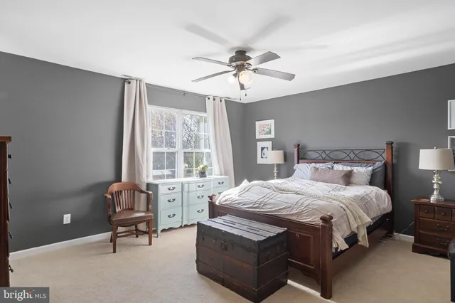 a bedroom with a bed a chair and a large window