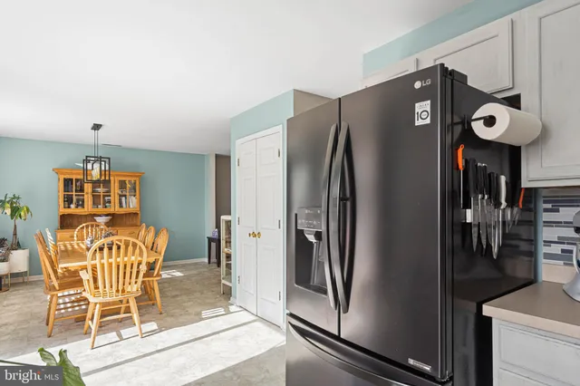 a view of a kitchen with refrigerator and dining table