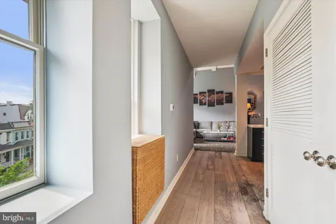 a view of a hallway with wooden floor and windows
