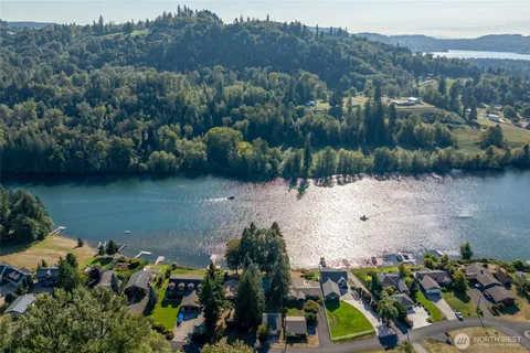 an aerial view of a house with a yard lake and mountain view