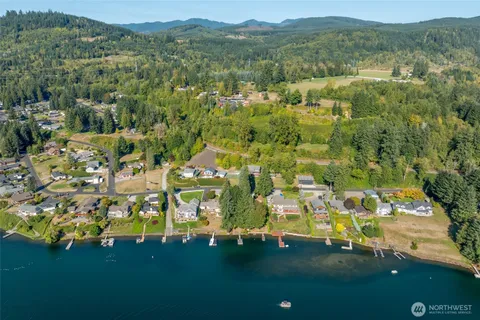 an aerial view of residential houses with outdoor space and trees all around