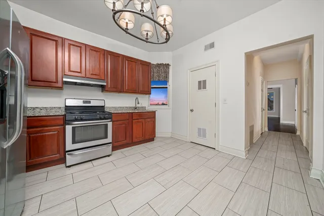 a kitchen with stainless steel appliances granite countertop a stove top oven a sink and cabinets