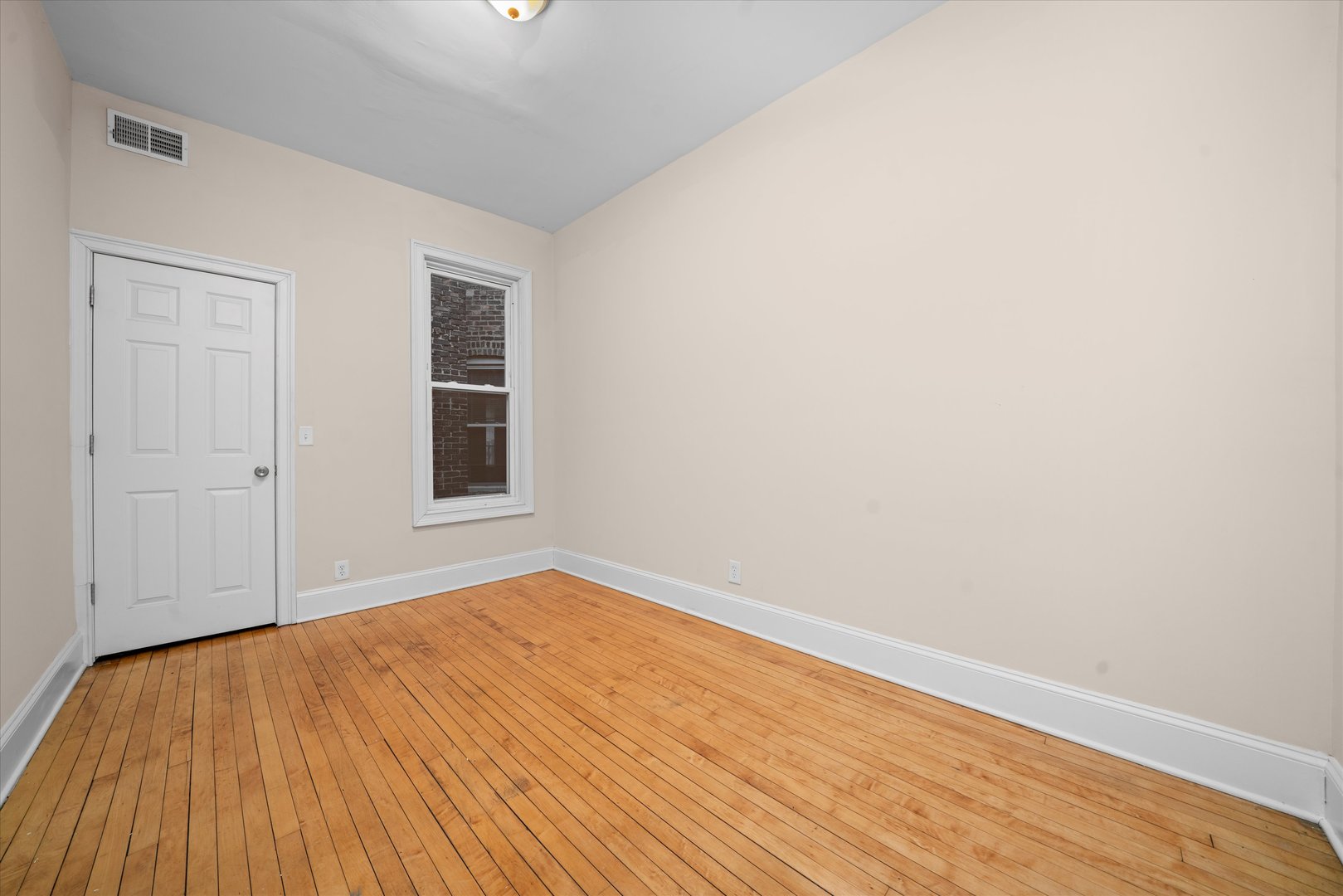 2128 West Cermak Road Chicago, IL 60608 - Photo 14 of 16 an empty room with wooden floor and windows