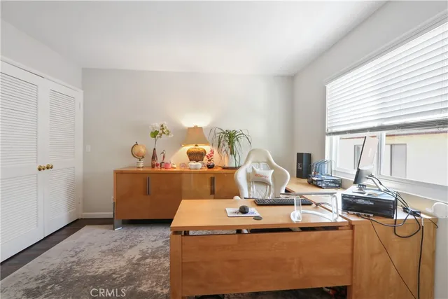 a work room with furniture a flat screen tv and a window
