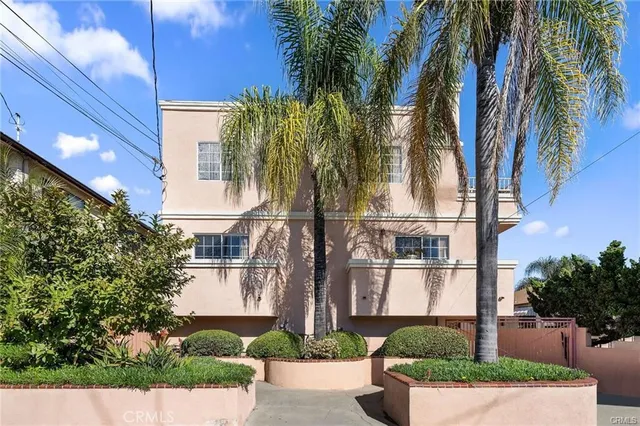 a front view of multi story residential apartment building with yard and green space