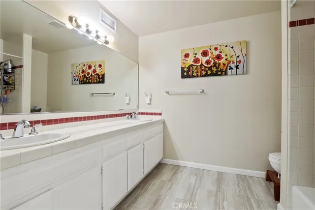 a bathroom with a sink a mirror and a picture on the wall