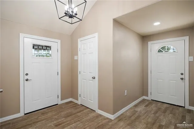 an empty room with wooden floor and ceiling fan