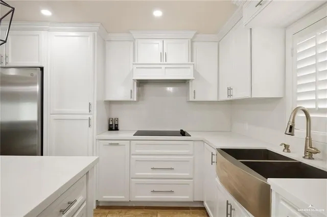 a kitchen with white cabinets and appliances