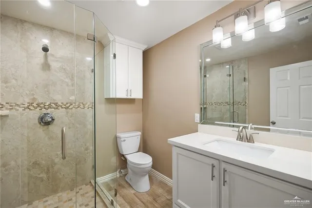 a bathroom with a sink a toilet and shower