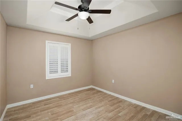 an empty room with a window and a fan