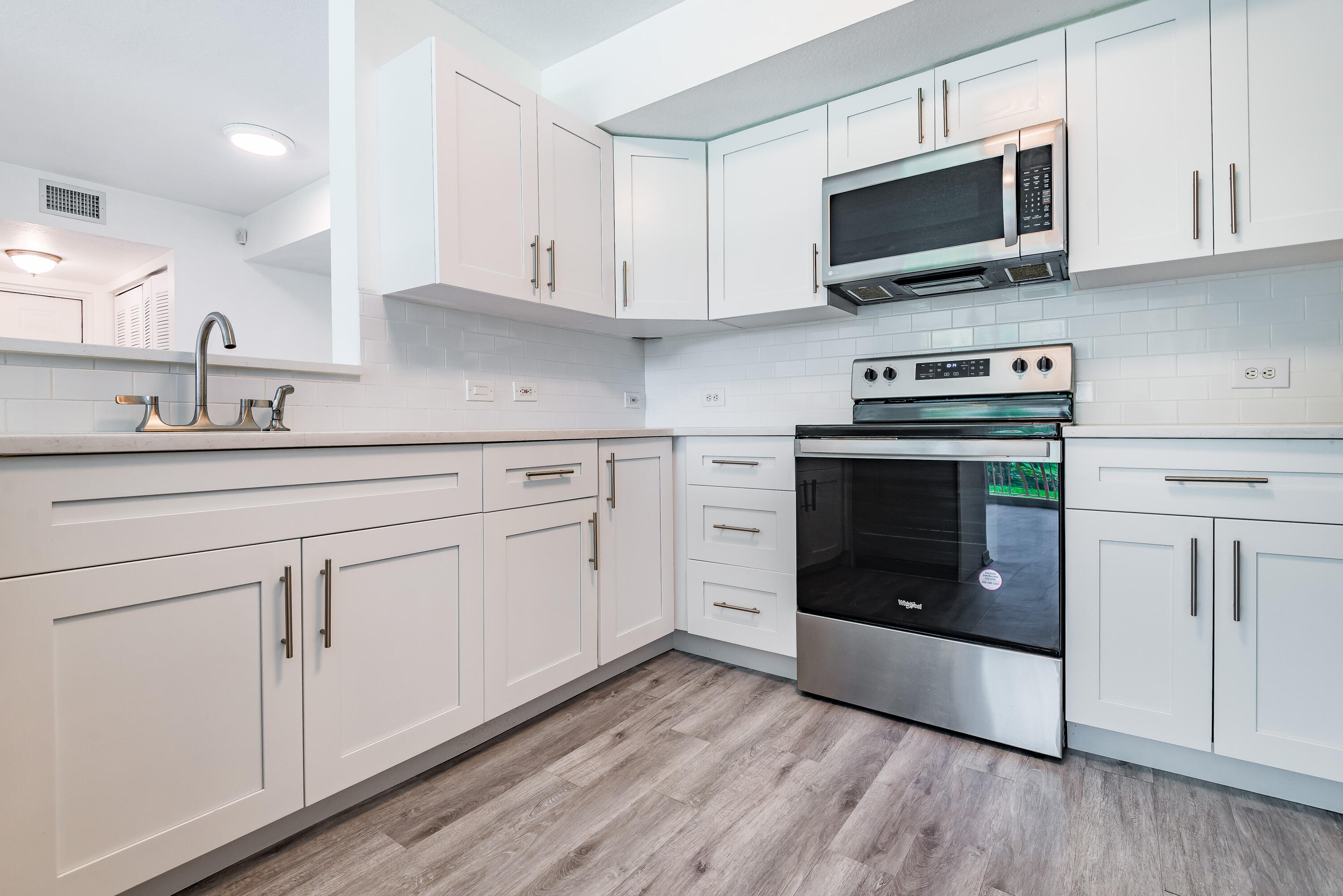 602 Villa Circle Boynton Beach, FL 33435 - Photo 3 of 27 a kitchen with stainless steel appliances granite countertop a stove microwave and sink