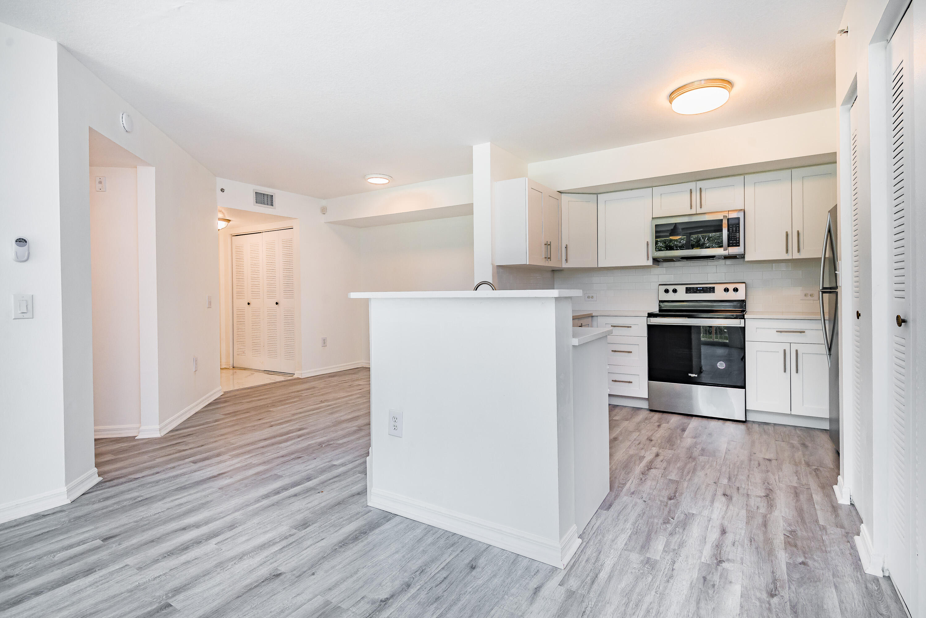 602 Villa Circle Boynton Beach, FL 33435 - Photo 4 of 27 a kitchen with granite countertop a refrigerator a stove top oven and wooden floor