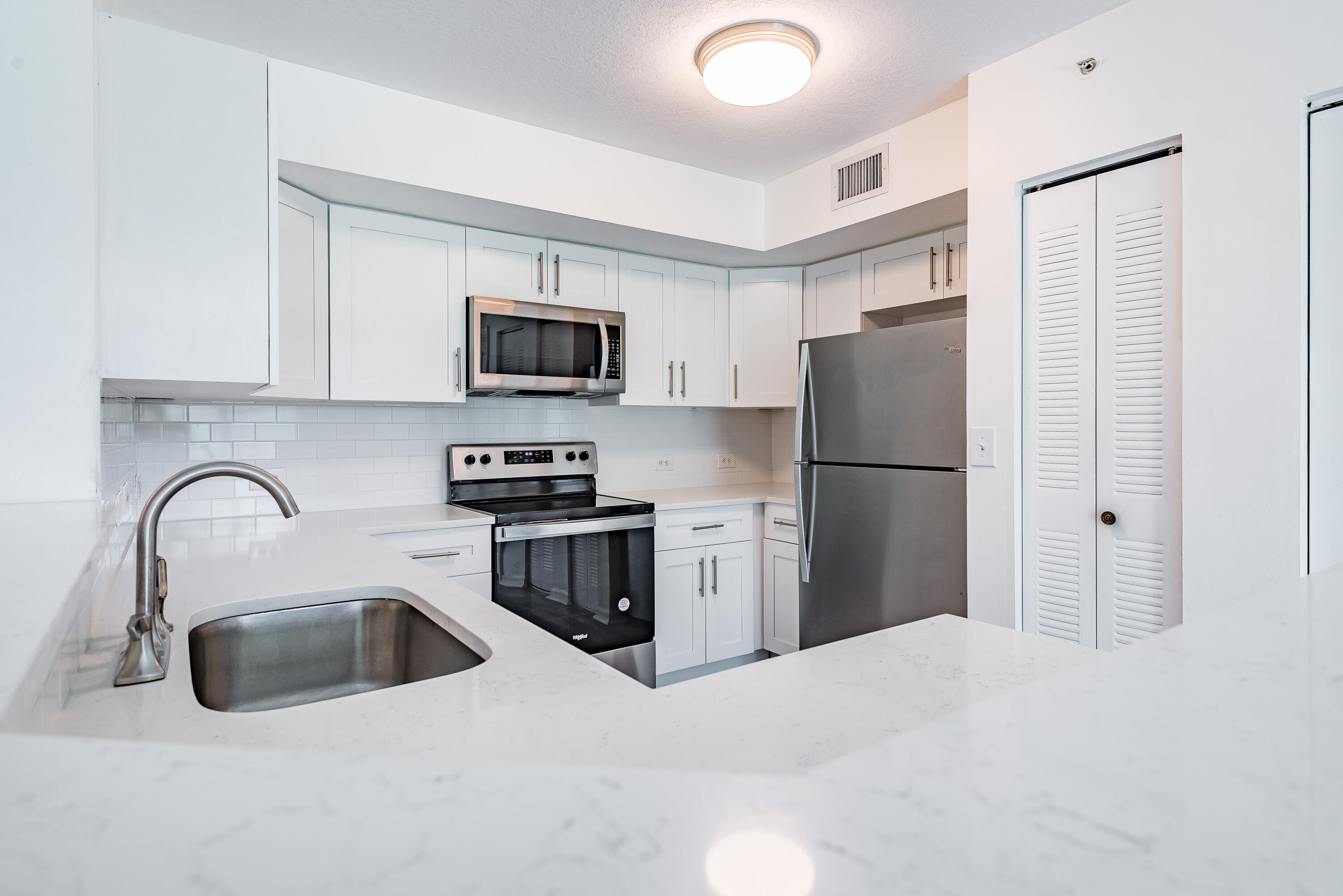 602 Villa Circle Boynton Beach, FL 33435 - Photo 5 of 27 a kitchen with a refrigerator sink and stainless steel appliances