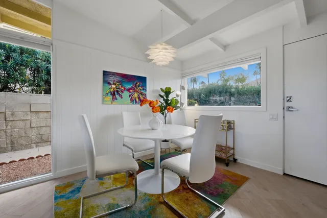 a view of a dining room with furniture a chandelier and wooden floor