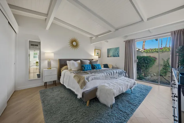 a spacious bedroom with a large bed and a wooden floor