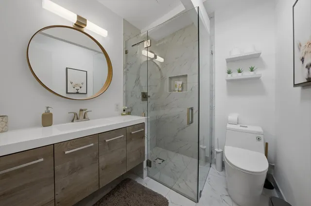 a bathroom with a toilet a sink a mirror and vanity