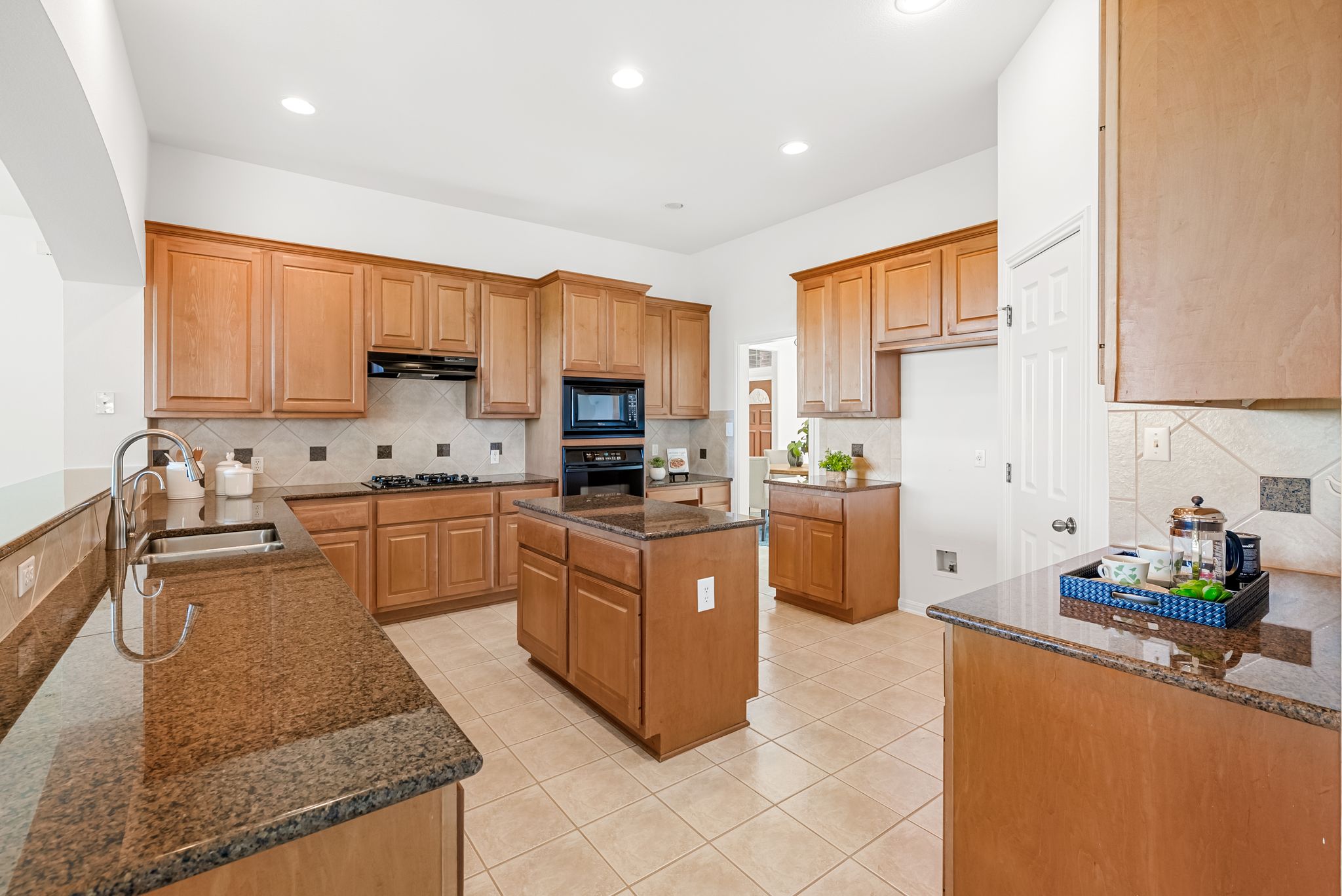 2708 Rio Mesa Drive Austin, TX 78732 - Photo 14 of 40 a kitchen with kitchen island granite countertop a sink counter top space appliances and cabinets