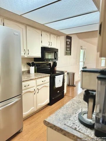 a kitchen with appliances a sink and cabinets