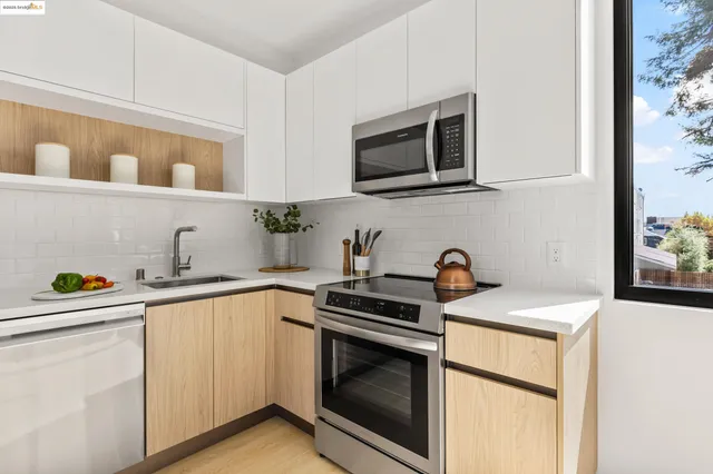 a kitchen with stainless steel appliances granite countertop a sink a stove a microwave and wooden cabinets