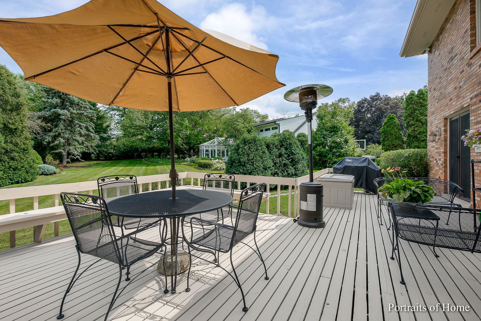 45 Cambridge Drive Oak Brook, IL 60523 - Photo 32 of 41 a view of a roof deck with table and chairs under an umbrella with wooden floor
