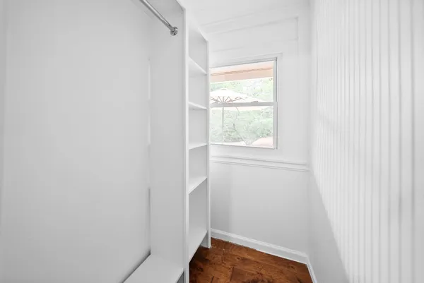 a view of empty room with wooden floor