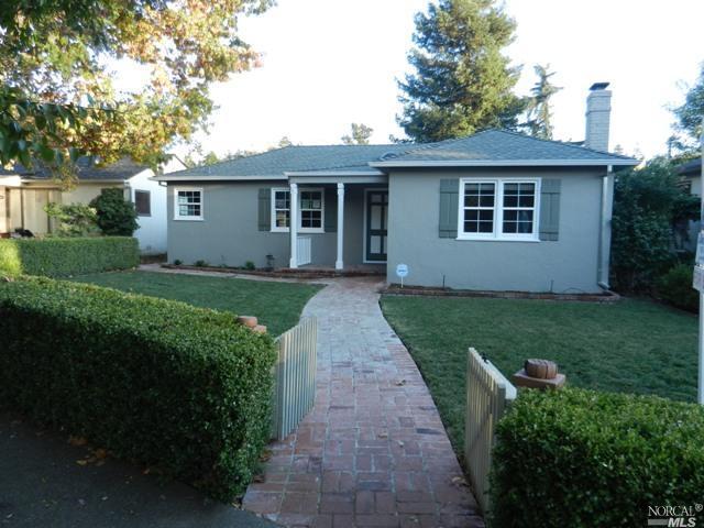 a front view of a house with a garden and yard
