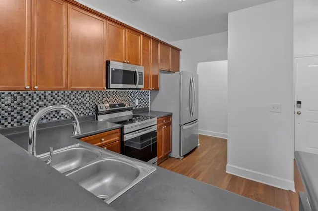 a kitchen with stainless steel appliances granite countertop a refrigerator stove and sink
