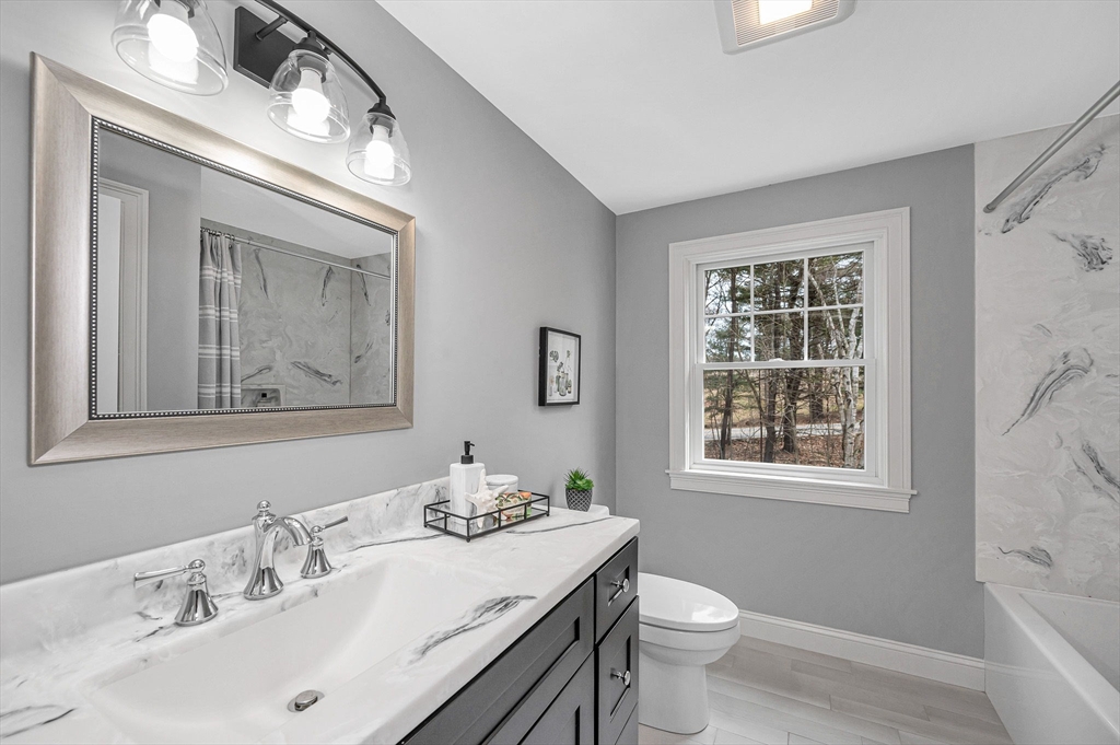 29 Washington Street Boxford, MA 01921 - Photo 32 of 39 a bathroom with a granite countertop toilet a sink a mirror and a window