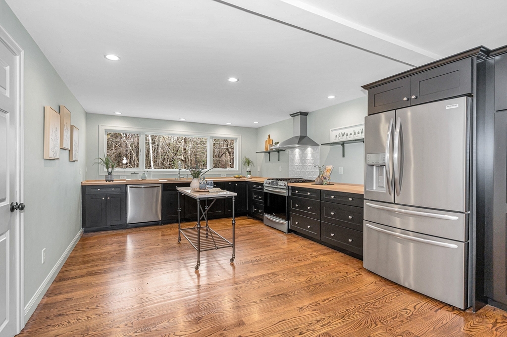 29 Washington Street Boxford, MA 01921 - Photo 10 of 39 a kitchen with stainless steel appliances kitchen island granite countertop a refrigerator and a stove top oven