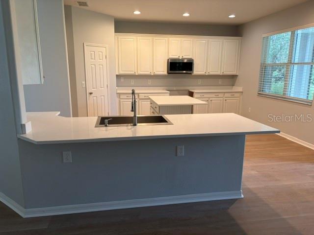 1885 Scrub Jay Road Apopka, FL 32703 - Photo 4 of 29 a kitchen with kitchen island a sink white cabinets and stainless steel appliances