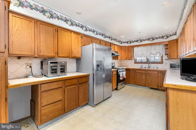 a kitchen with stainless steel appliances a refrigerator sink and cabinets
