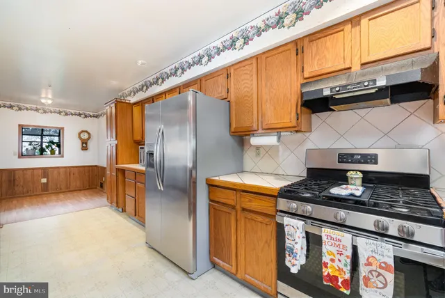 a kitchen with stainless steel appliances granite countertop a stove a sink and a refrigerator