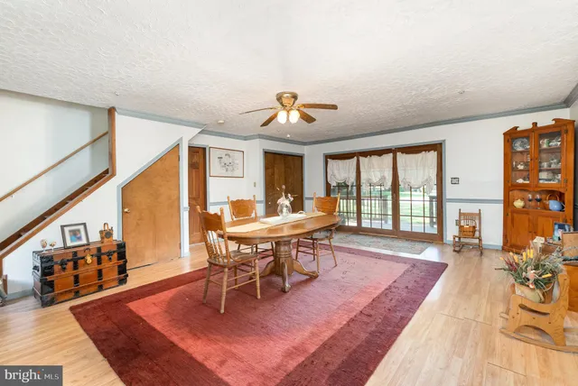 a dining room with wooden floor a chandelier a wooden table and chairs