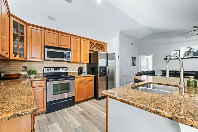 a kitchen with stainless steel appliances granite countertop a sink stove and refrigerator
