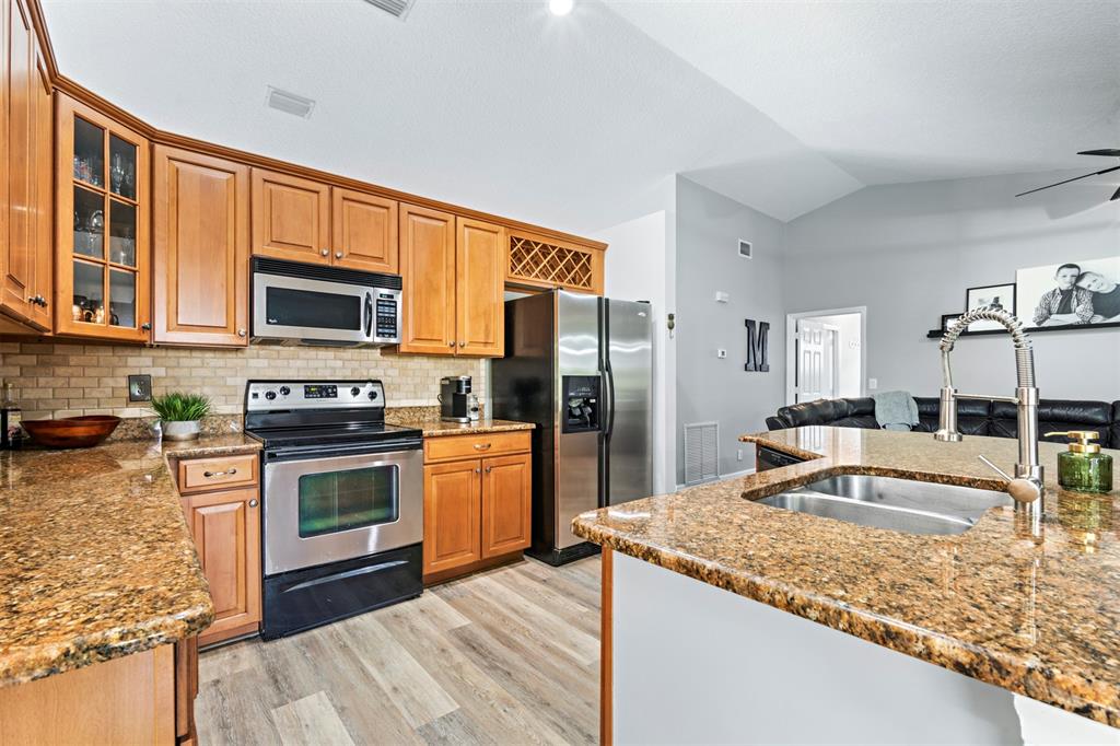 5133 Northwest 47th Avenue Coconut Creek, FL 33073 - Photo 11 of 44 a kitchen with stainless steel appliances granite countertop a sink stove and refrigerator